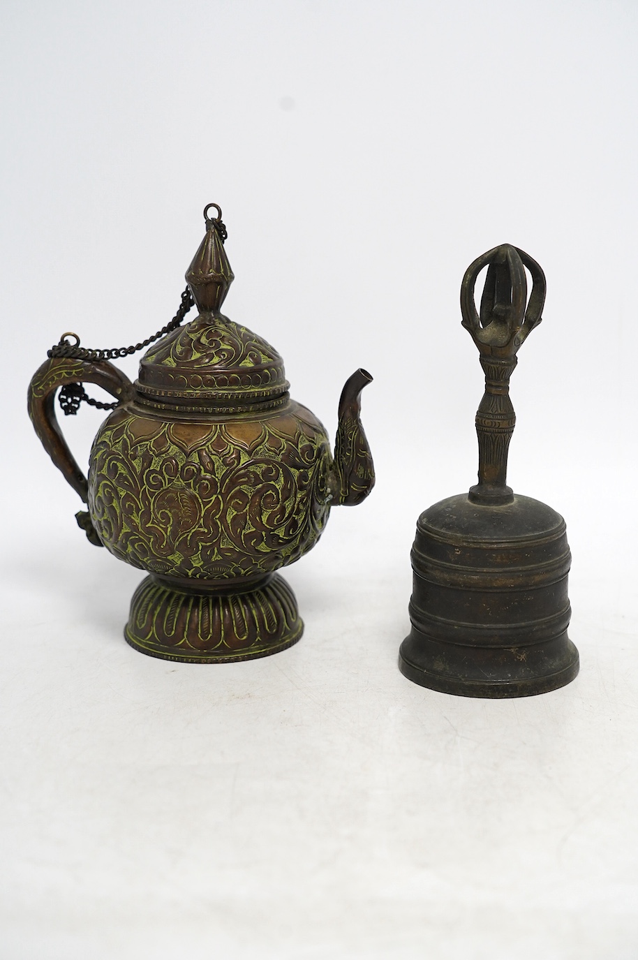 A 19th century Tibetan bronze ghanta bell and a 19th century Tibetan repousse copper teapot, tallest 18cm. Condition - fair to good